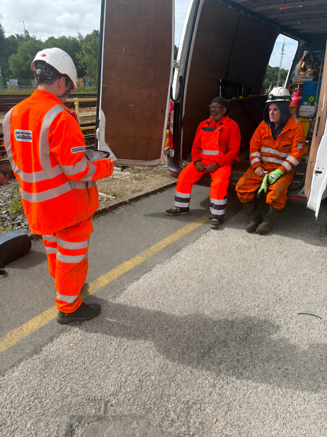 Railway workers in safety gear discussing